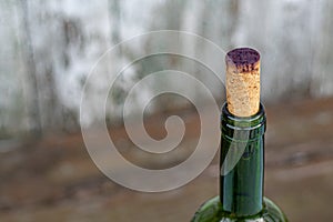 Wine bottle corked by old stopper stained by purple wine