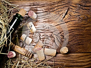 Wine bottle and corks on the wooden table.
