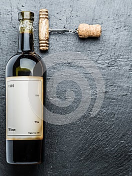 Wine bottle and corkscrew on the graphite board