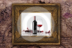 Wine bottle with glass and bunch of red grapes on old classic wooden frame carved by hand on wood background