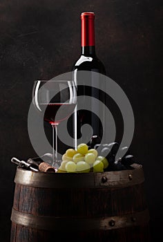 Wine bottle, glass and old wooden barrel