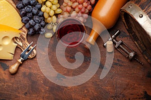 Wine bottle, grapes, glass of red wine and old barrel