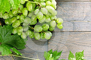 Wine bottle and grapes on wooden table. Top view with space for