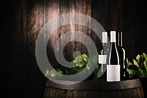 Wine. Bottle of red wine with ripe grapes over wooden background