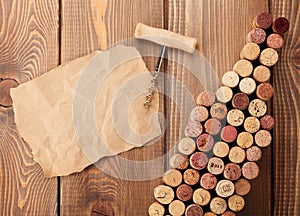 Wine bottle shaped corks, corkscrew and piece of paper