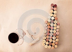 Wine bottle shaped corks, glass of wine and corkscrew