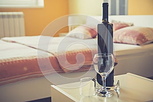 Wine bottle and two glasses in bedroom