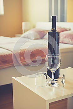Wine bottle and two glasses in bedroom