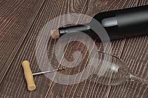 Wine bottle with vintage label and corkscrew on wooden table top background