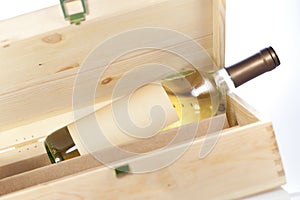 Wine bottle in wooden box closeup on white backgound