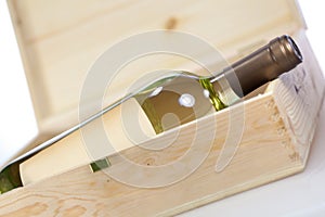 Wine bottle in wooden box closeup on white backgound