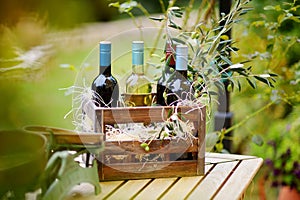 Wine bottle in a wooden crate decorated with olive branches
