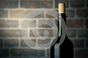 Wine bottle on a wooden table with bricks wall background close