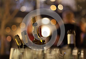 Wine bottles, glass and bokeh.