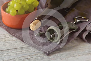 Wine bottles, glass, corkscrew, grapes on table. top view.