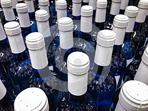 Wine bottles - many blue bottles with white label / bottlenecks