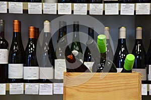Wine bottles on wooden shelf in wine store