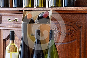 Wine bottles on wooden shelf in wine store, restaurant, bar and ready for home delivery
