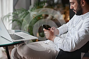 wine business owner reading a message on his smartphone.