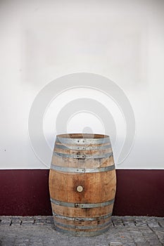 Wine cask leaning against a traditionally painted Alentejo wall.