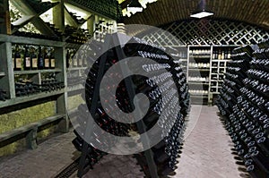 Wine cellar. The bottles on wooden shelves. Vintage storage of wine collection