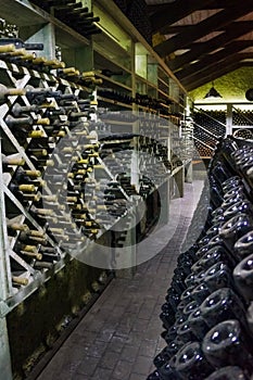 Wine cellar. The bottles on wooden shelves. Vintage storage of wine collection