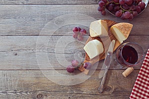 Wine, cheese and grapes on wooden table. View from above with copy space