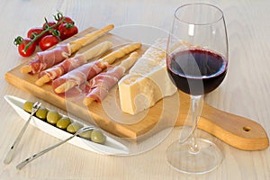 Wine with cheese, olives, tomatoes, prosciutto