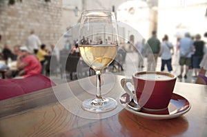 Wine and coffee at a cafe, crowded street background