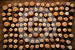 Wine corks of different sizes, standing upright on an old wooden surface. Background for liquor