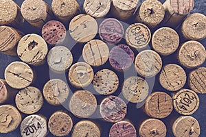 Wine corks grape shape and vine on stone table.