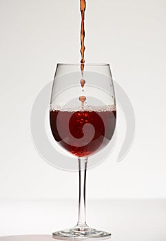 Wine drops fall in glass