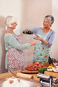 Wine, food and happy senior women in home for toast to lunch, supper and dinner together with friends. Alcohol, cooking