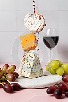 Wine fountain on levitating soft goat cheese, cheddar and blue stilton with grape