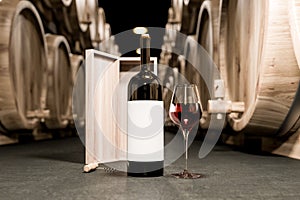 Wine glass and bottle on concrete wine cellar floor