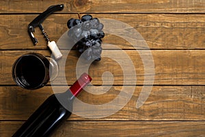 Wine glass bottle opener corks and grapes on wooden background. Top view with copy space