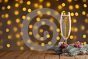 Wine glass with bubbly Champagne on blurry sparkling lights background