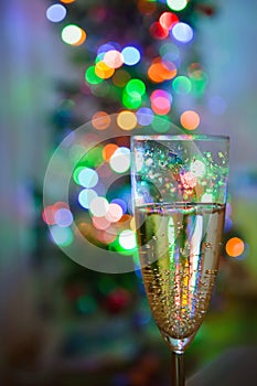 Wine glass with champagne is on a background of multicolored lig