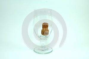 Wine glass and champagne cork on white background.