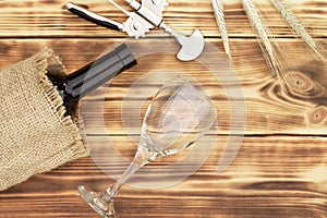 Wine glass, corkscrew, corks, wine bottles, grapevine on rustic burnt wooden background. Top view. Copy space