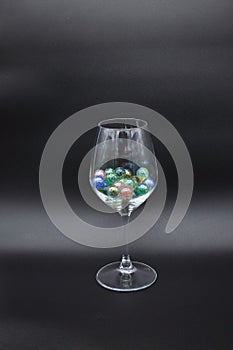 Wine glass filled with colored glass marbles