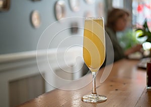 A wine glass filled with a mimosa at an indoor restaurant