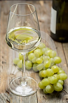 Wine glass with grapes on a wooden background