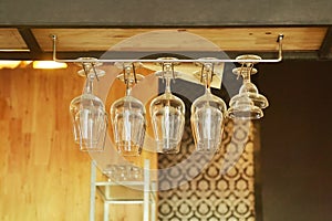 wine glass hanging on rack above counter bar