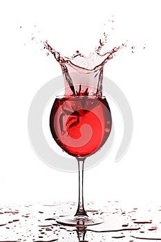 Wine glass with liquid splash on white