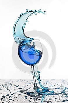 Wine glass with liquid splash on white