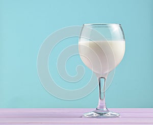 Wine glass of natural milk on a pastel background, nostalgia, minimalism trend, copy space.