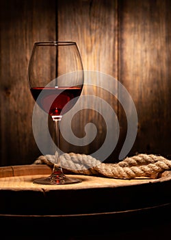 Wine glass and old wooden barrel close-up