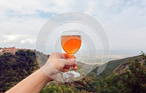 Wine glass over green hills horizon. Natural winemaking and ecological leisure