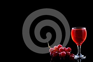 Wine glass and red grapes with drops on blak backgound. Space fot text menu